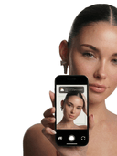 Woman holding a smartphone with a mirror app on the screen, showing the functionnality of the ai hair scanner