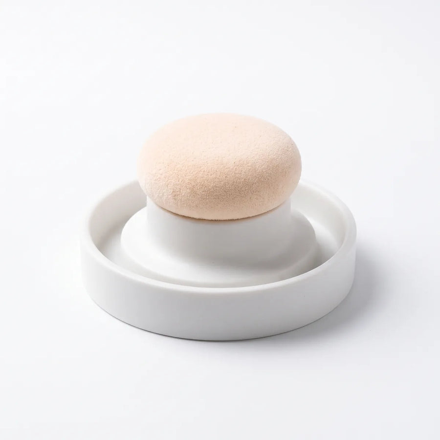 The wide puff applicator in its white holder